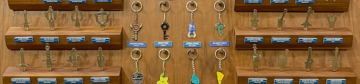 A walnut display featuring a variety of house key and keychain designs at a trade show