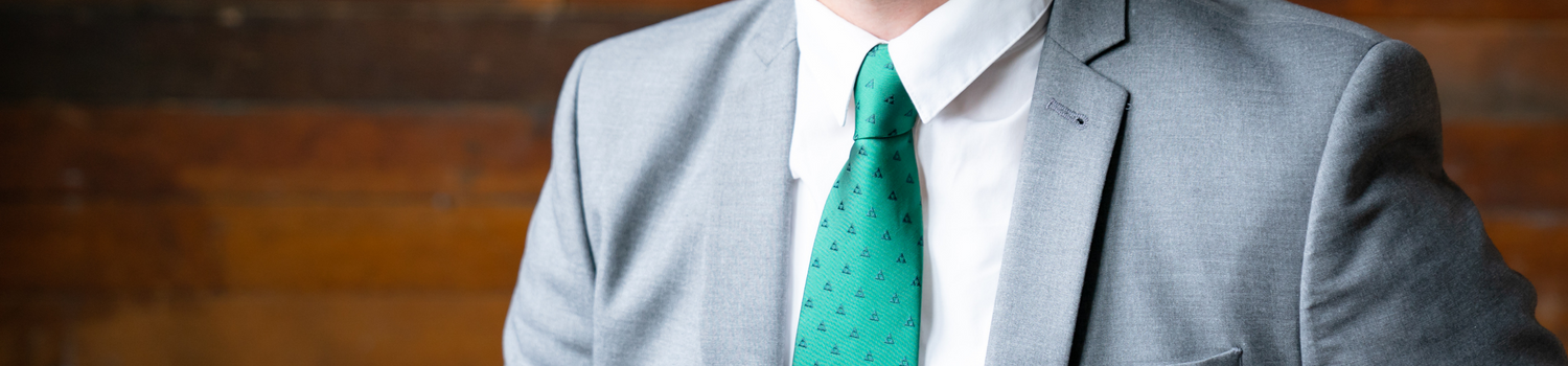 A man in a gray suit wearing a green tie