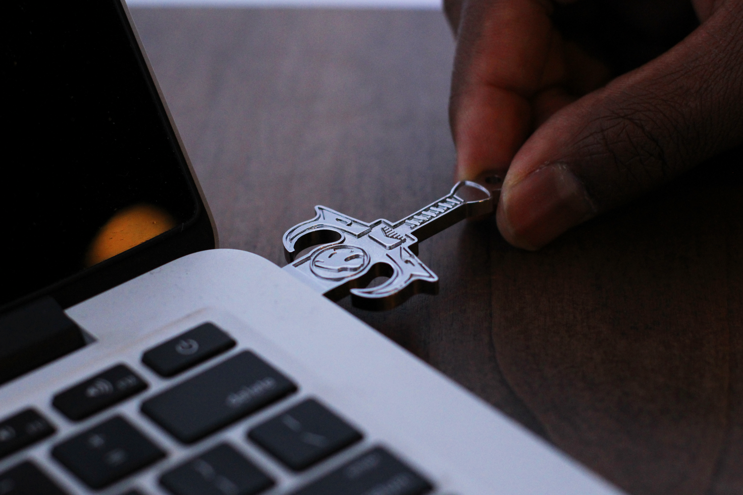 A silver USB drive being plugged into a computer