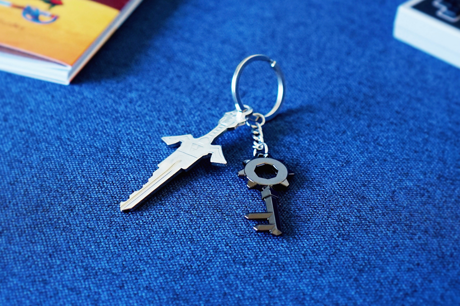 A silver key and black keychain on a blue background