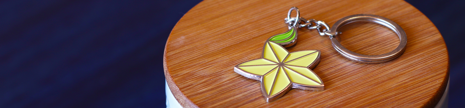 A yellow and green keychain on an oak piece of wood
