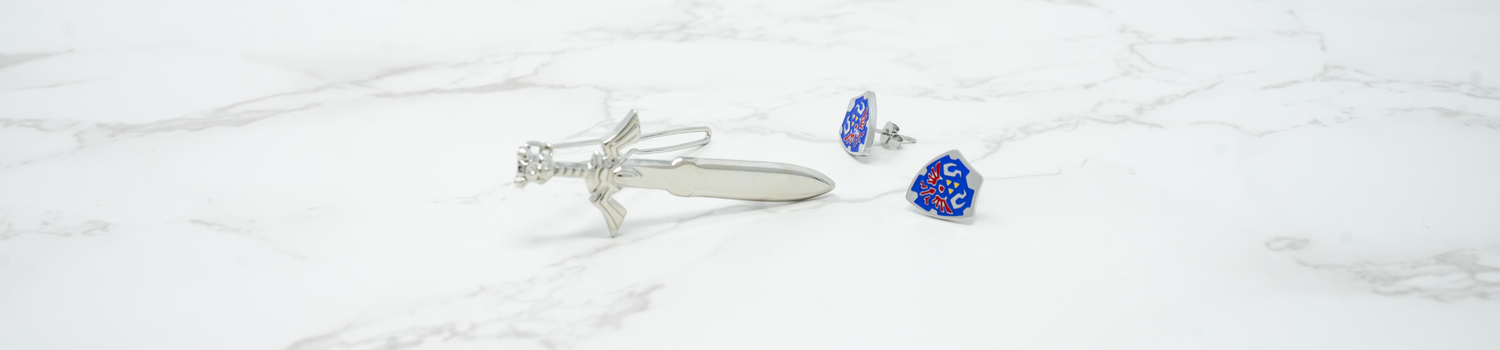 A silver hair clip next to a pair of blue, yellow and red earrings